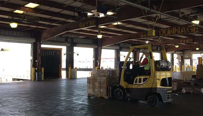 A forklift operator using FreightSnap's FS 5000 pallet dimensioner at a trucking terminal.